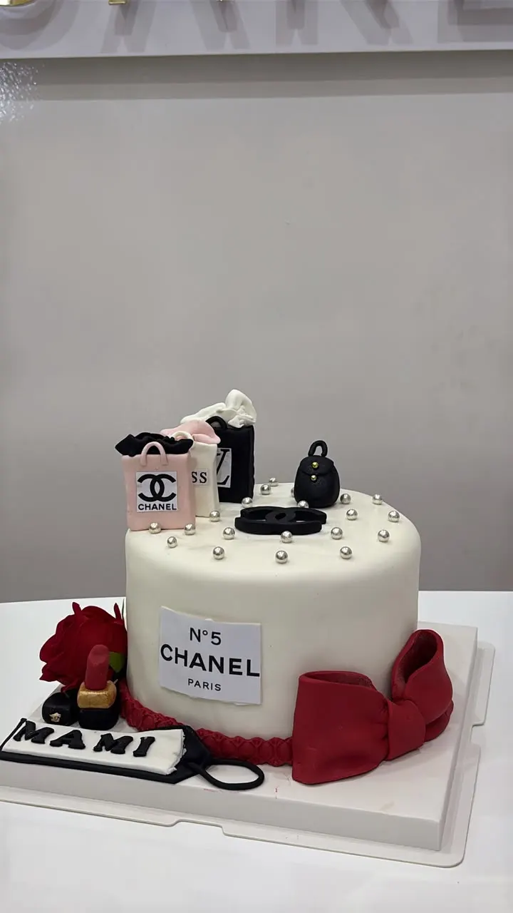 Gâteau blanc élégant orné de perles et d'un nœud rouge en pâte à sucre