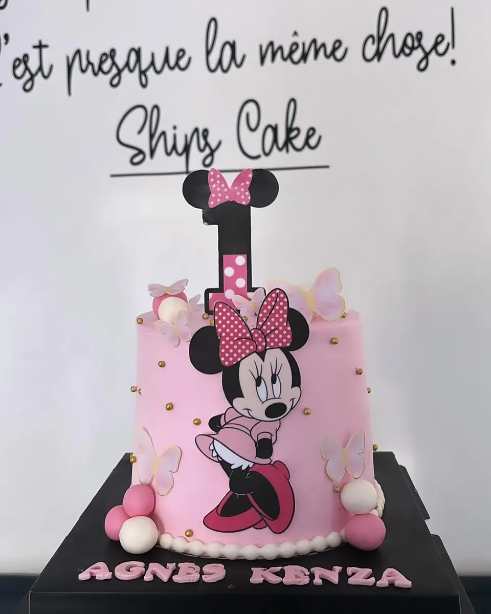 Gâteau rose décoré de Minnie, perles et nœud, avec le prénom de l'enfant