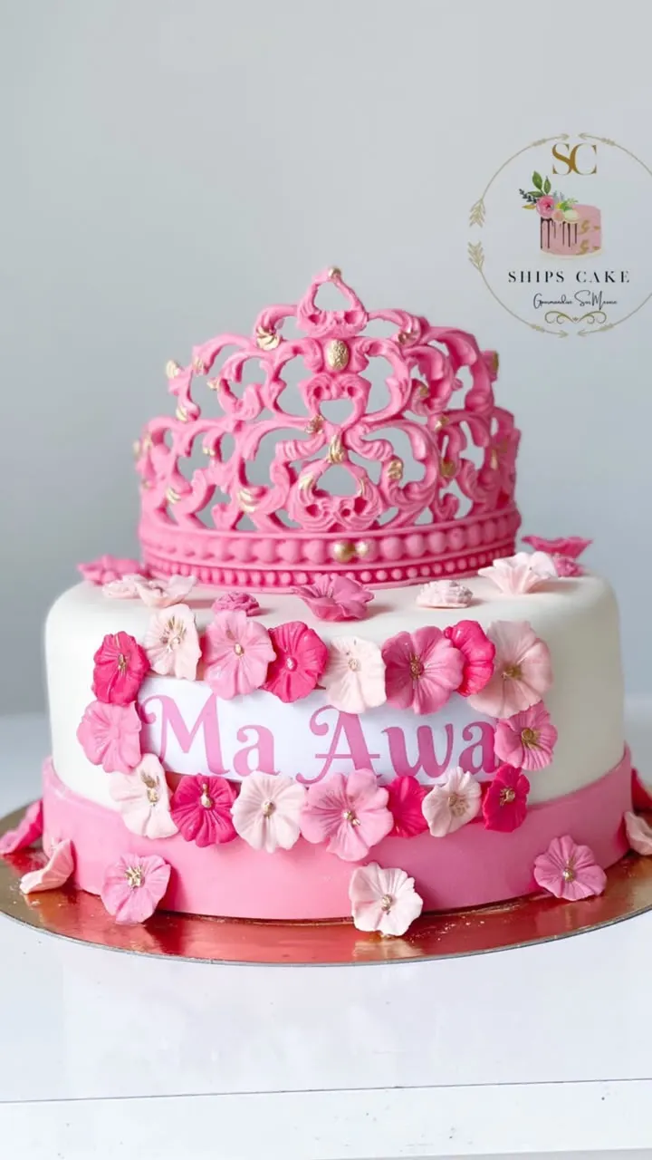 Gâteau à deux étages rose et blanc, couronne et fleurs en sucre