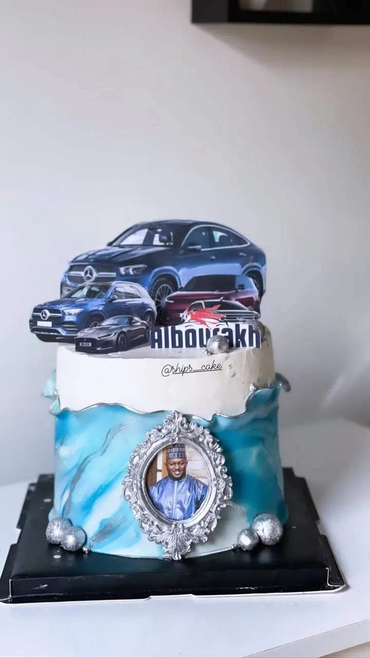 Gâteau bleu et blanc décoré de voitures et d'un médaillon photo