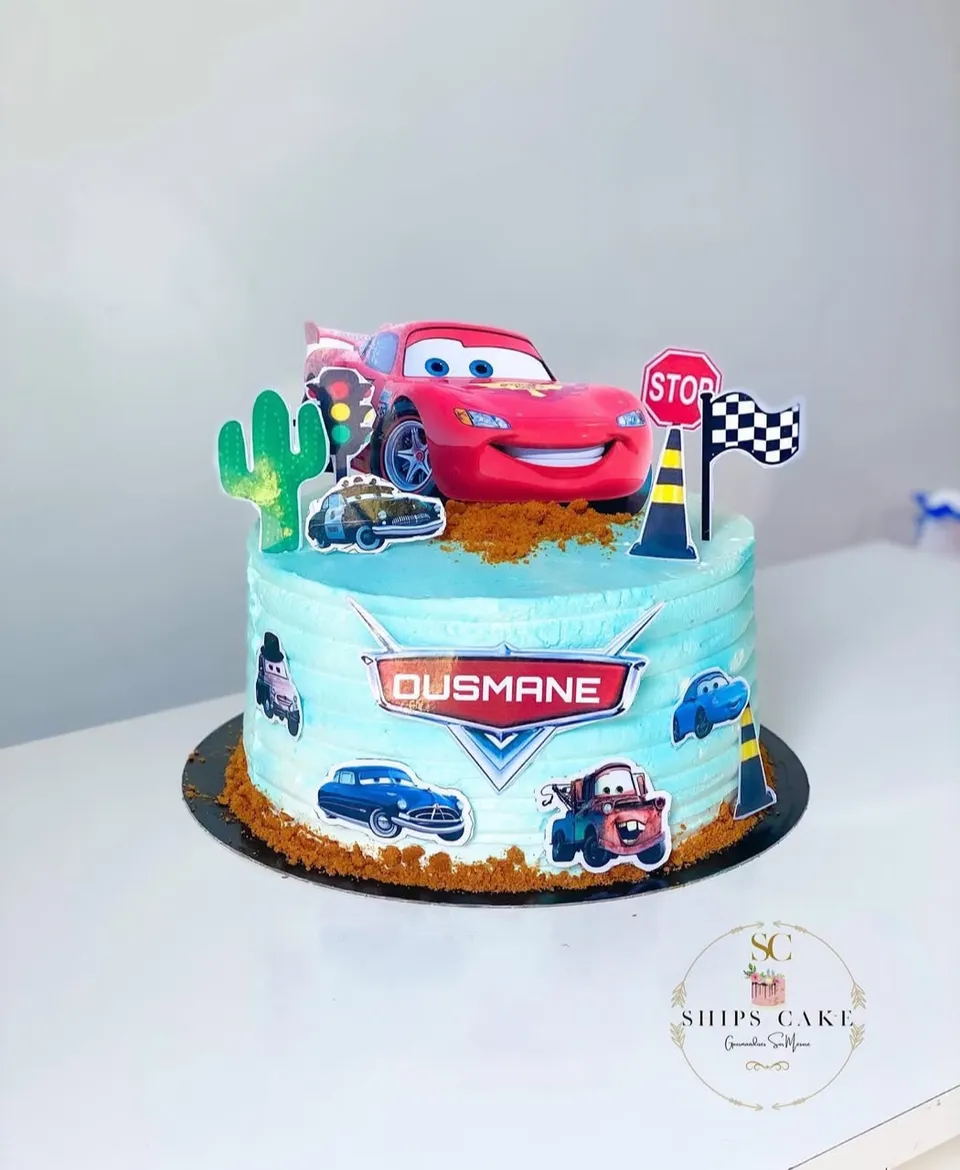 Gâteau bleu clair sur le thème Cars, avec la voiture rouge, un cactus et un drapeau à damier