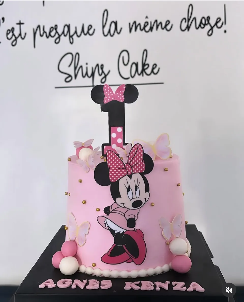 Gâteau rose décoré de Minnie, avec un nœud à pois, des papillons et des perles dorées