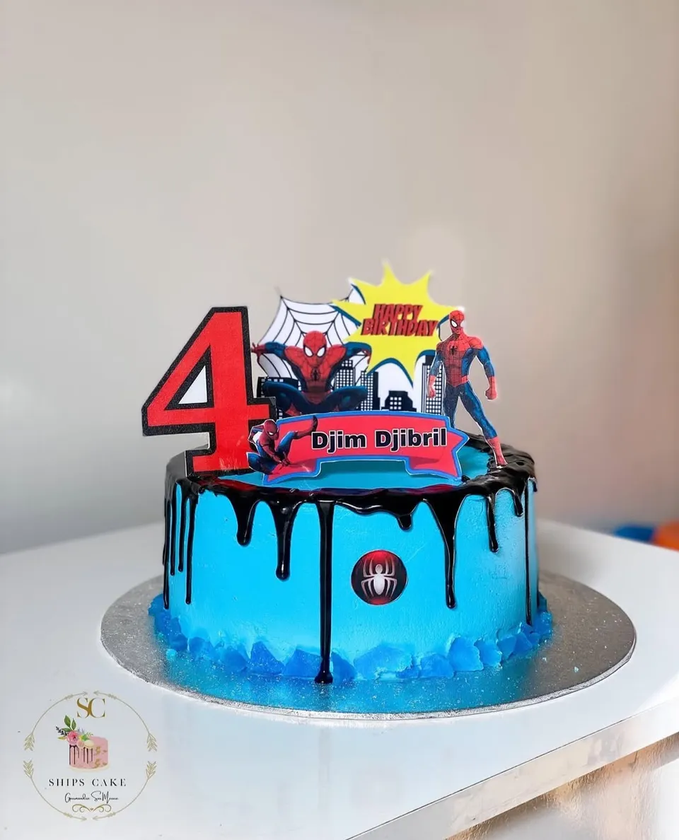 Gâteau bleu avec coulure de chocolat noir sur le thème Spider-Man, avec une figurine