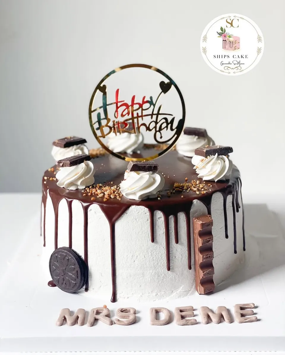 Gâteau à la crème blanche avec coulure de chocolat, chantilly, carrés de chocolat et biscuits