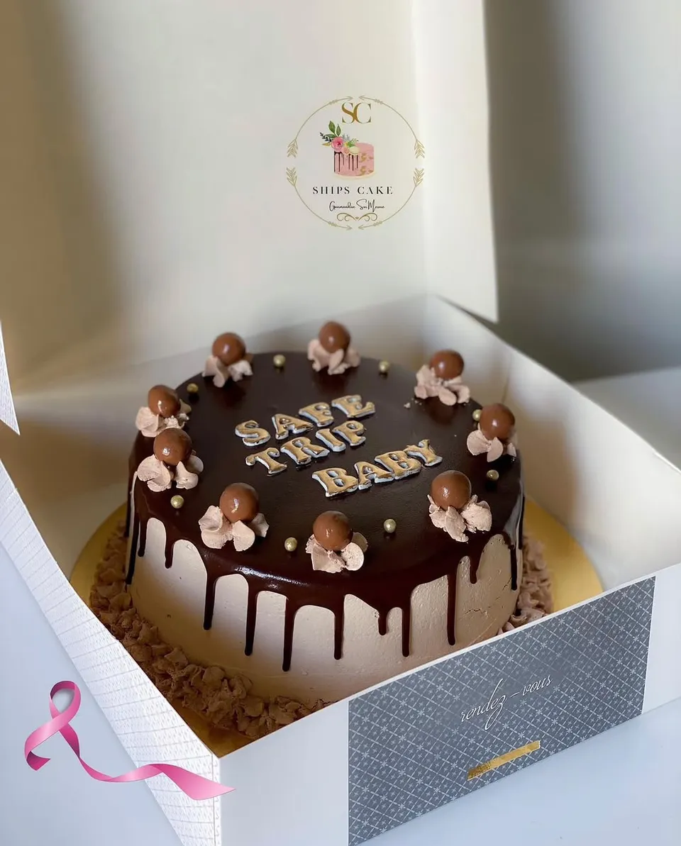 Gâteau au chocolat nappé de ganache, avec billes chocolatées, rosaces de crème et perles dorées