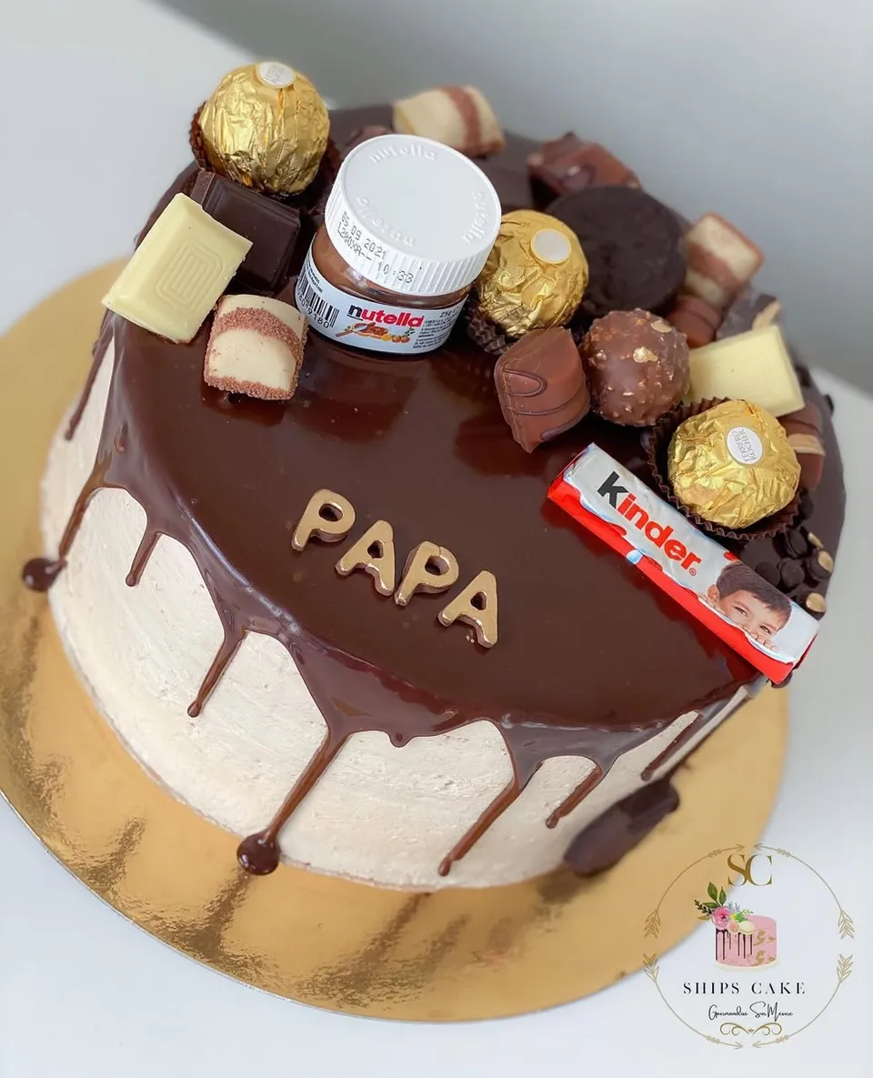 Gâteau nappé de ganache et garni de chocolats assortis et de barres chocolatées