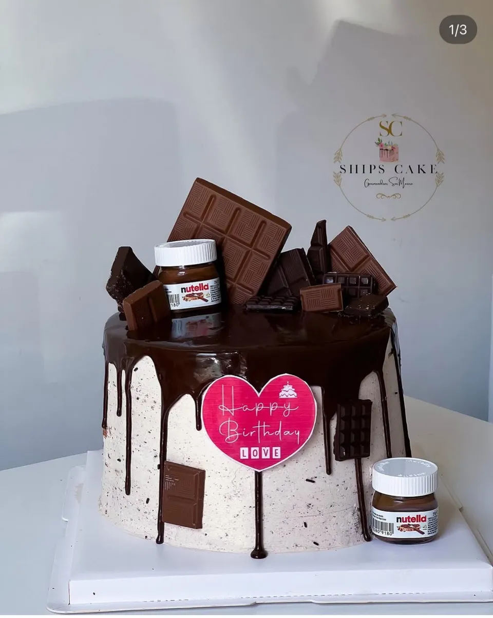 Gâteau à coulure de chocolat surmonté de tablettes de chocolat et d'un pot de pâte à tartiner